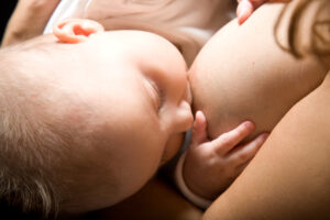 Baby saugt an Mutterbrust