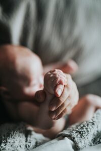 Babyhand hält Hand von Person